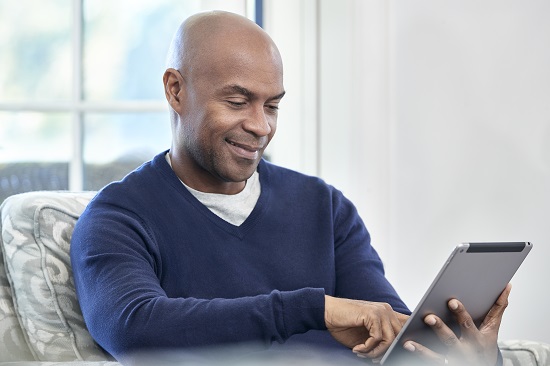 Man smiling while using tablet