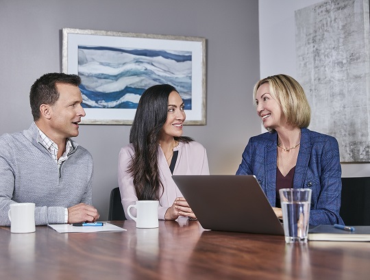 Financial advisor assisting couple on laptop